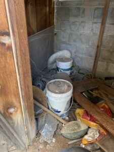 A cluttered shed corner with buckets, wire mesh, and wood scraps, ready for cleanout by Roadrunner JunkSmart Solutions LLC in Las Cruces, NM.