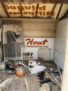 The cluttered interior of a shed filled with old signs, debris, and a refrigerator coil, ready for cleanout by Hagen's Junk Removal in Fort Collins, CO.