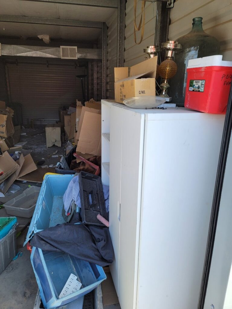 A cluttered storage unit filled with boxes and furniture, indicating a cleanout job by Gone Junkin' Vegas in Henderson, NV.