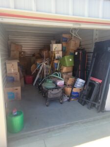 A cluttered storage unit filled with boxes and items, indicating a cleanout job for Valley Haul Off LLC in Visalia, CA.