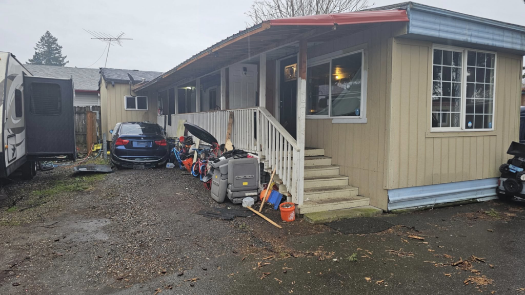 A cluttered residential yard filled with various items and debris, indicating a junk removal or cleanup service by Can Do Andrew in Gresham, OR.