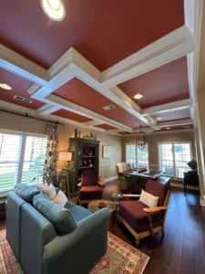 A beautifully designed living and dining area with a red coffered ceiling and crown molding, installed by Safe Haven Home Services in Nashville, TN.