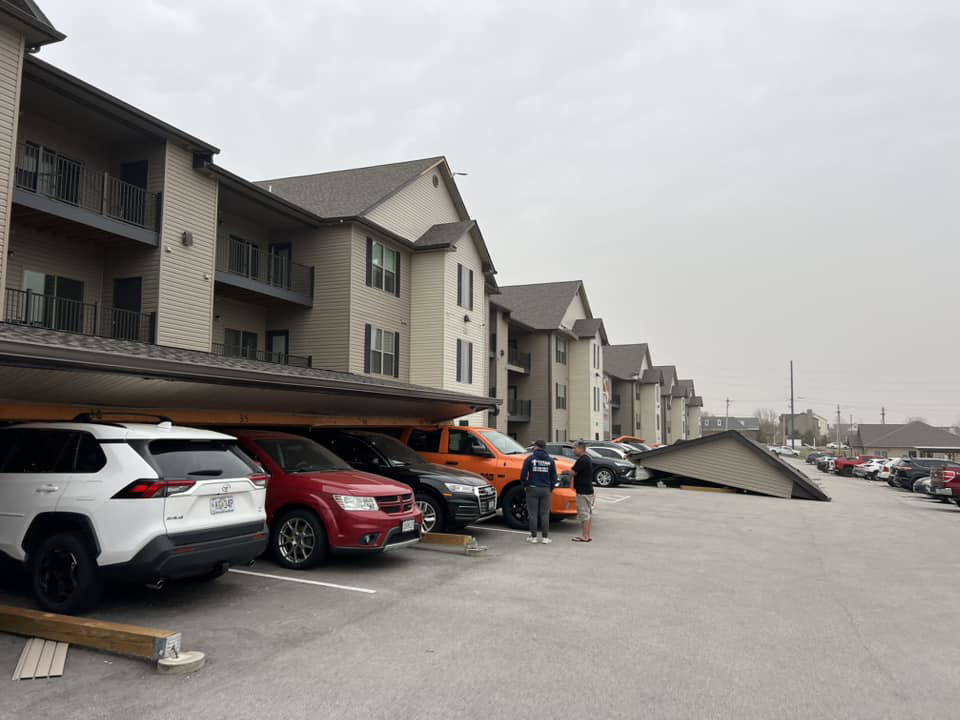 A collapsed carport structure at an apartment complex, showing damage requiring repair by Larson Exteriors in Sunset Hills, MO.