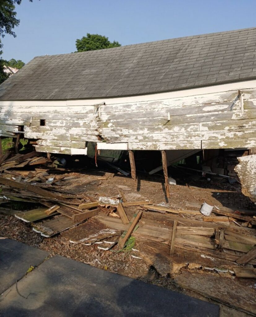 A collapsed wooden shed with debris underneath, awaiting removal by Black Diamond Junk Removal in Bedford Heights, OH.