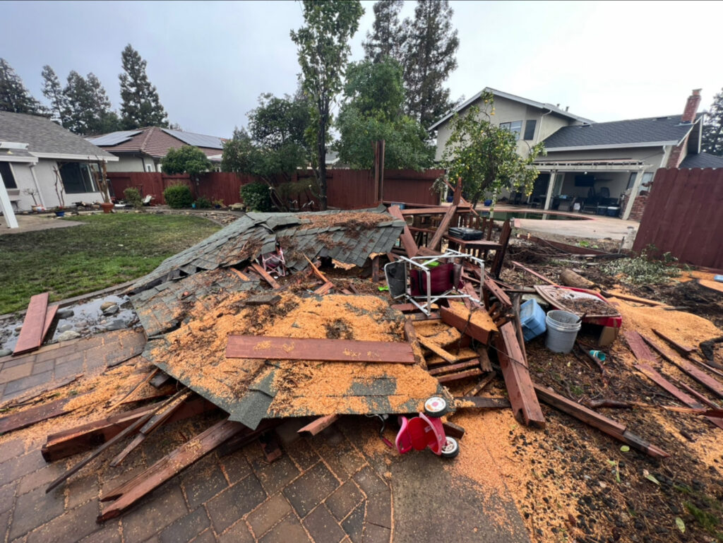 A collapsed wooden structure and debris in a backyard, requiring removal by Sac Junk in Rancho Cordova, CA