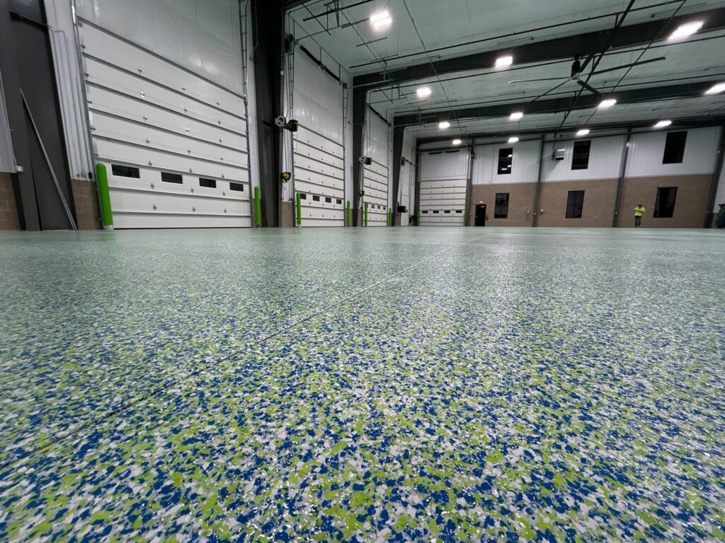 A vibrant green and blue epoxy flake floor in a commercial space by Premier Edge Concrete in Grand Rapids, MI