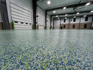 A vibrant green and blue epoxy flake floor in a commercial space by Premier Edge Concrete in Grand Rapids, MI