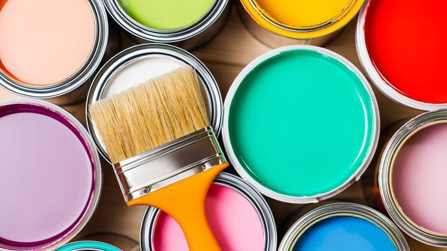 A collection of colorful open paint cans and a paintbrush, representing painting services from Picture Perfect Painting and Wallpapering Inc. in O Fallon, MO.