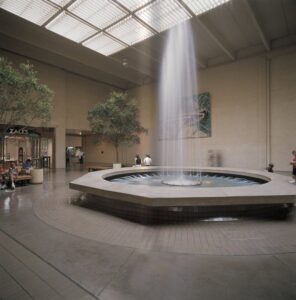 A spacious commercial atrium featuring a central fountain and skylights, a project by Dallas Cast Stone in Dallas, TX