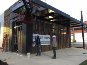 Workers installing a commercial awning and facade elements for Recreated in Birmingham, AL.