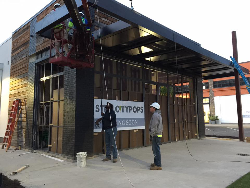 Workers installing a commercial awning and facade elements for Recreated in Birmingham, AL.