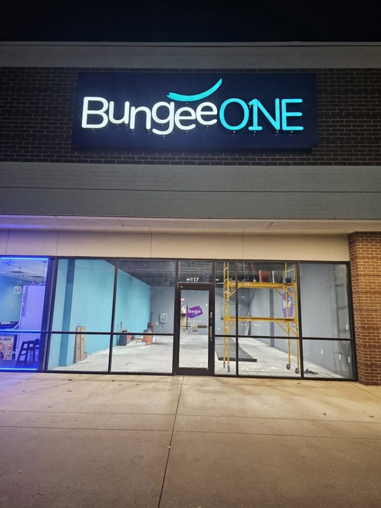 A commercial storefront for BungeeONE undergoing a build-out or renovation, showing scaffolding inside by M.M. Remodelers in Resaca, GA.