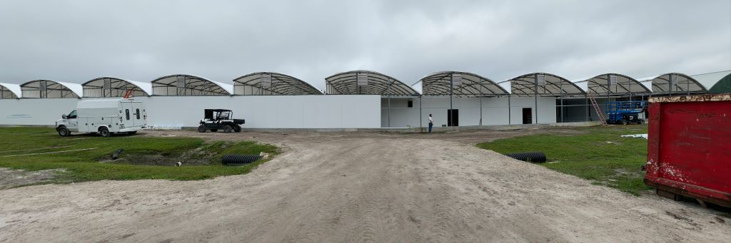 Exterior view of a large commercial building under construction with arched roofs, by Florida SIP Panels by ACS, Inc. in Tampa, FL