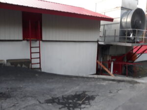 An industrial building exterior with a red ladder, suggesting commercial handyman services by Phoenix's Cleaning Service, LLC in Rutland, VT.