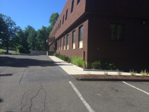 The exterior of a commercial building with a clean sidewalk and maintained landscaping by Discovery Enterprises LLC in Danbury, CT.