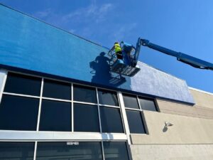 Workers on a boom lift painting the exterior of a commercial building by CMFM Construction in Columbia, MO
