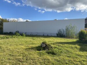 A freshly painted white exterior wall of a commercial building, showcasing painting services by Spectrum Paint and Commercial Services, Inc. in Houston, TX.