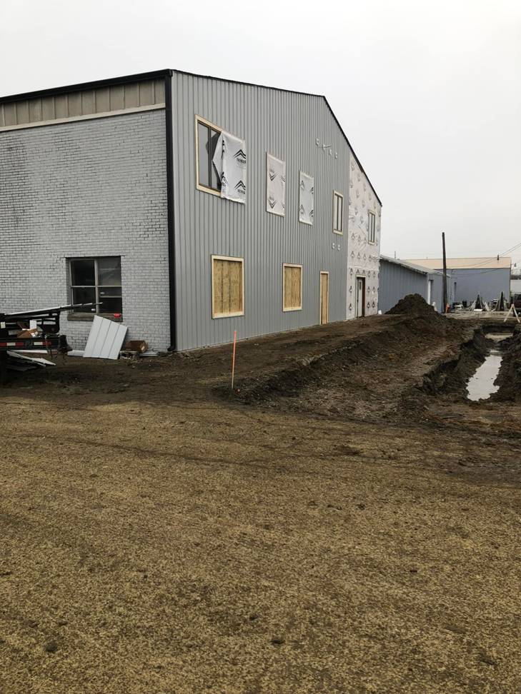 Commercial building exterior under construction with covered windows by American Enterprises Inc. in Waunakee, WI.