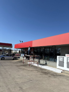 A handyman on scaffolding performing facade repair on a commercial building for Express Handyman Pros, LLC in Fort Smith, AR