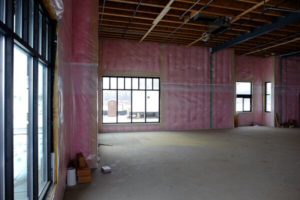 Interior of a commercial building with pink insulation installed on walls by Key Insulation in San Antonio, TX.