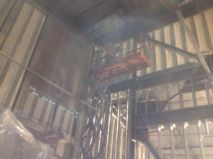 Commercial building insulation project with a scissor lift by Kwik Insulation in Spokane, WA.