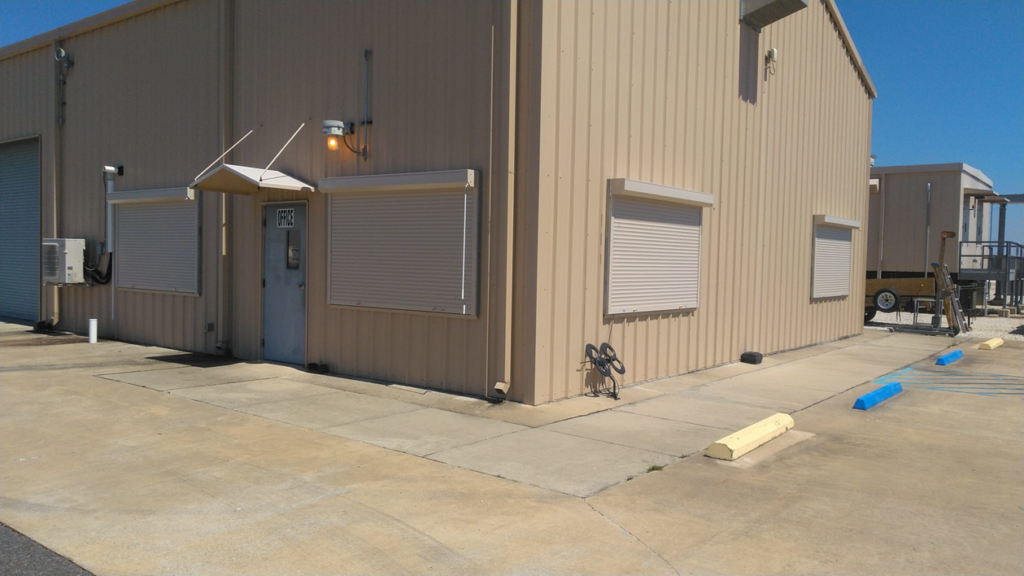 Exterior of a commercial building with newly installed security shutters by Lake Charles Construction LLC in Lake Charles, LA.