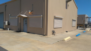 Exterior of a commercial building with newly installed security shutters by Lake Charles Construction LLC in Lake Charles, LA.