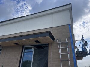 Commercial building exterior with new siding installation and construction equipment by M&J Florida Enterprise Llc in Orlando, FL.