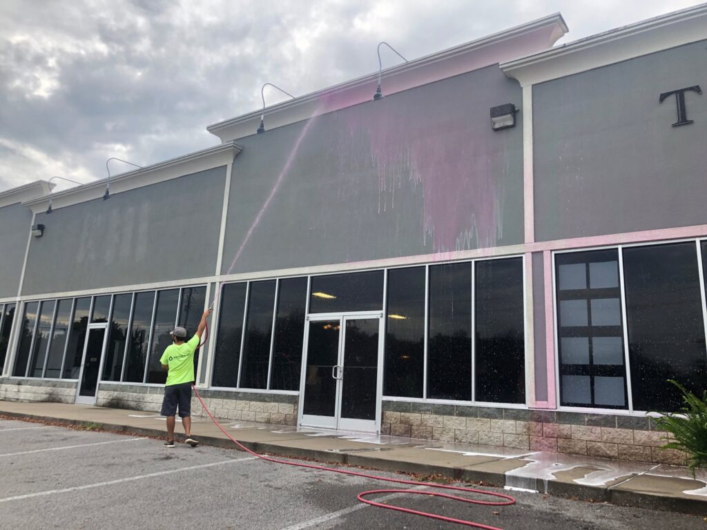 A Waterly, Co. Power Washing technician soft washing a commercial building exterior in Nashville, TN.