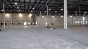 An interior view of a commercial building under construction, showing drywall and a scissor lift, by Valiant Electric Inc. in Kenosha, WI.