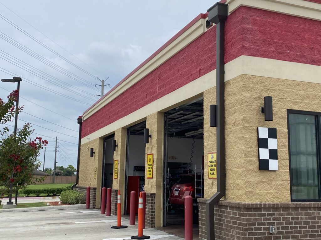 Exterior view of a newly constructed or renovated commercial car service center, a general contractor project by Spectrum Paint and Commercial Services, Inc. in Houston, TX.
