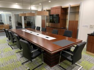 A newly completed commercial conference room fit-out with a large wooden table by Florida Palm Construction, Inc. in Davie, FL