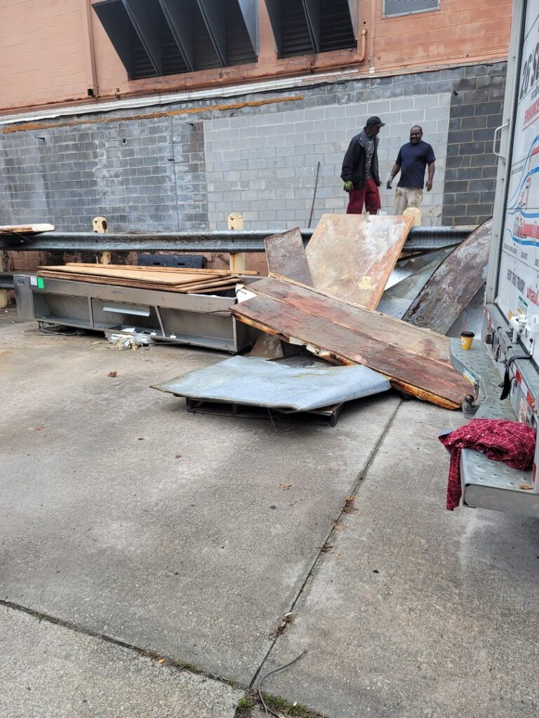 Workers loading commercial debris and scrap for junk removal by Jugganott Recycling, LLC in Orlando, FL.