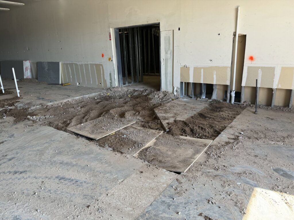 Piles of dirt and rubble on the floor of a commercial space after demolition, indicating debris removal by HAVOC Demolition in Scottsdale, AZ.