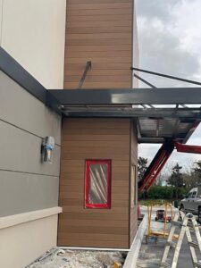 Commercial drive-thru building undergoing siding renovation by M&J Florida Enterprise Llc, a general contractor in Orlando, FL.