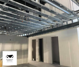 Commercial space under construction with metal ceiling framing and new drywall walls by Waterbury Drywall in Waterbury, CT.