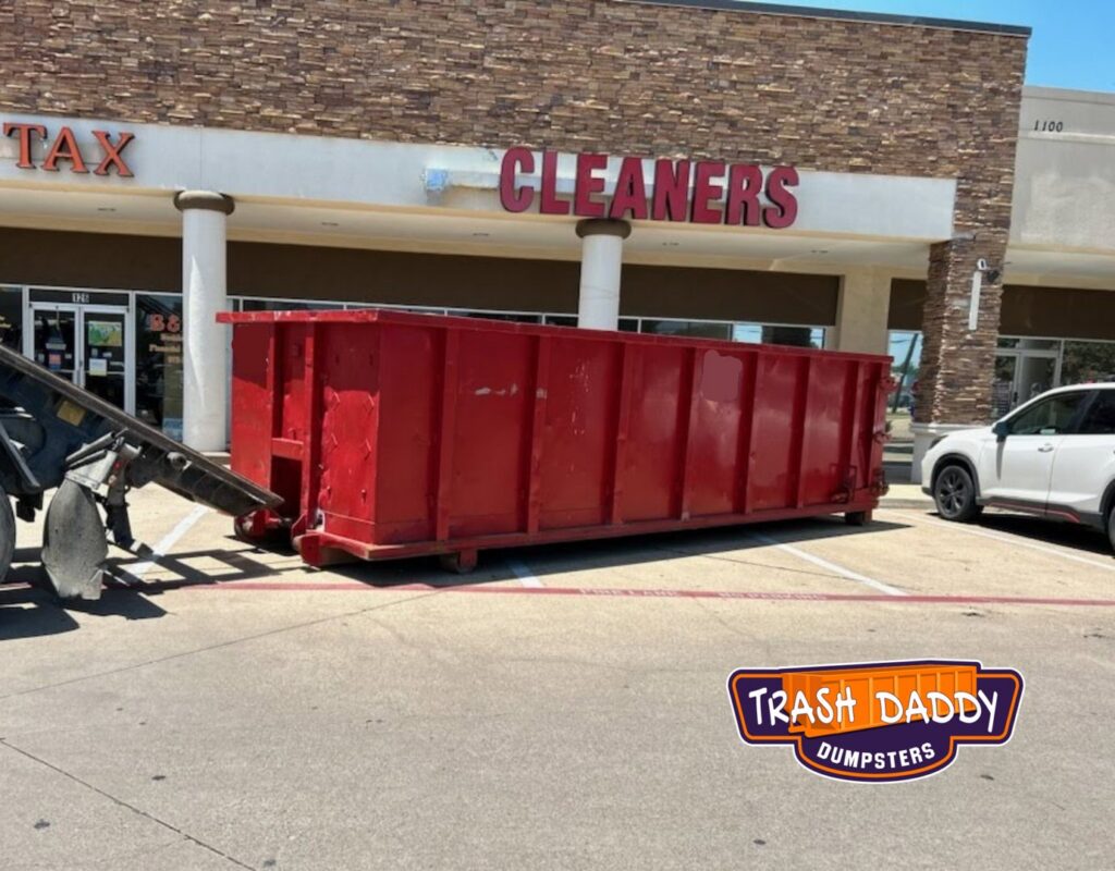 A red dumpster being delivered to a commercial business by Trash Daddy in Fort Worth, TX