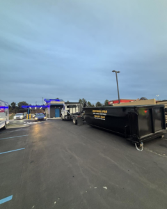 A Disposal Pro Haul Away Services truck with a branded dumpster in a commercial parking lot in Charlotte, NC.