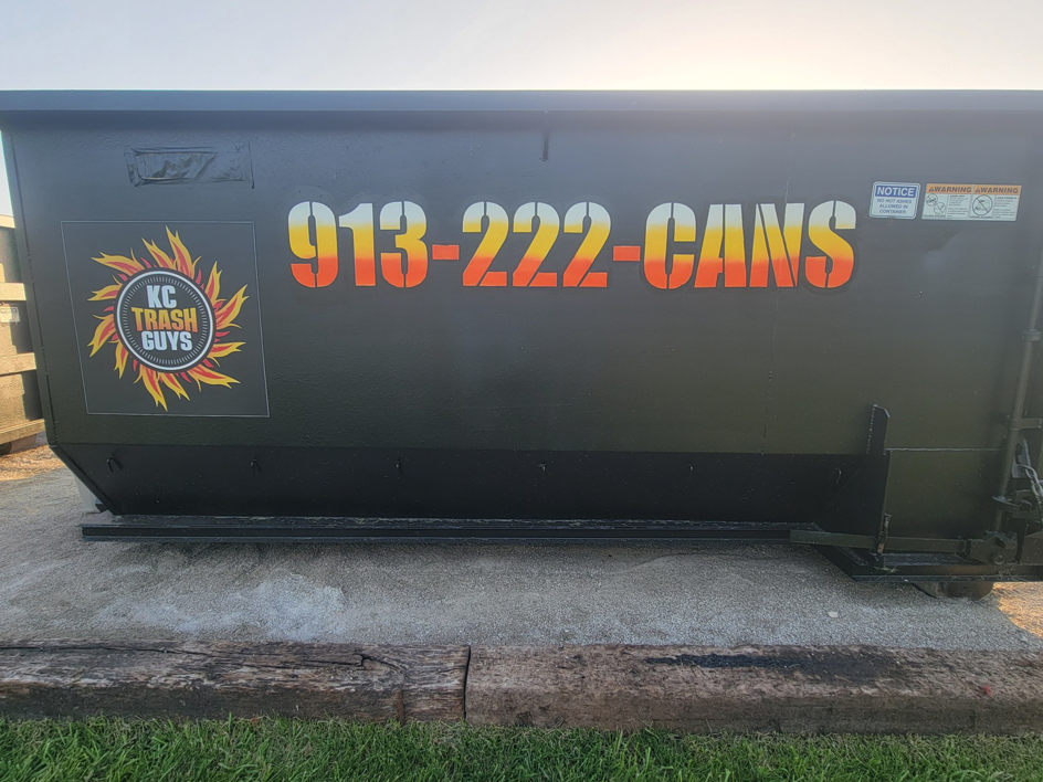 A KC TRASH GUYS LLC dumpster on a concrete pad for commercial junk removal in Johnson county, MO.