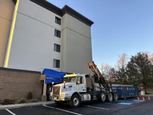 A Broco Waste & Recycling truck with a dumpster providing service at a commercial building in Warminster, PA.