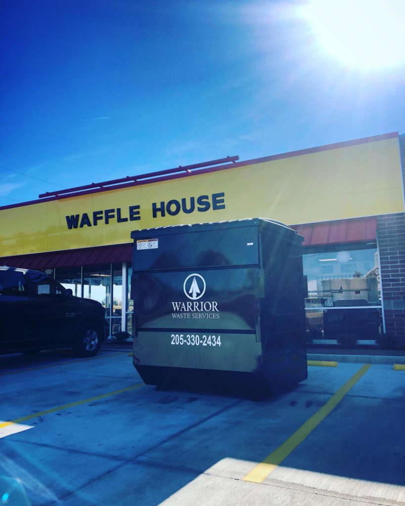 A commercial dumpster from Warrior Waste Services placed outside a Waffle House in Northport, AL.