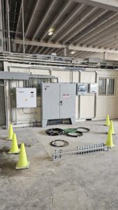 A commercial electrical installation with multiple panels, conduits, and safety cones by Denali Electric LLC in San Antonio, TX