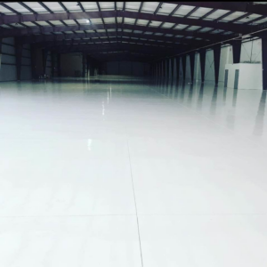 A large commercial space with newly installed shiny white epoxy flooring by Catalyst Contracting in Cape Coral, FL.