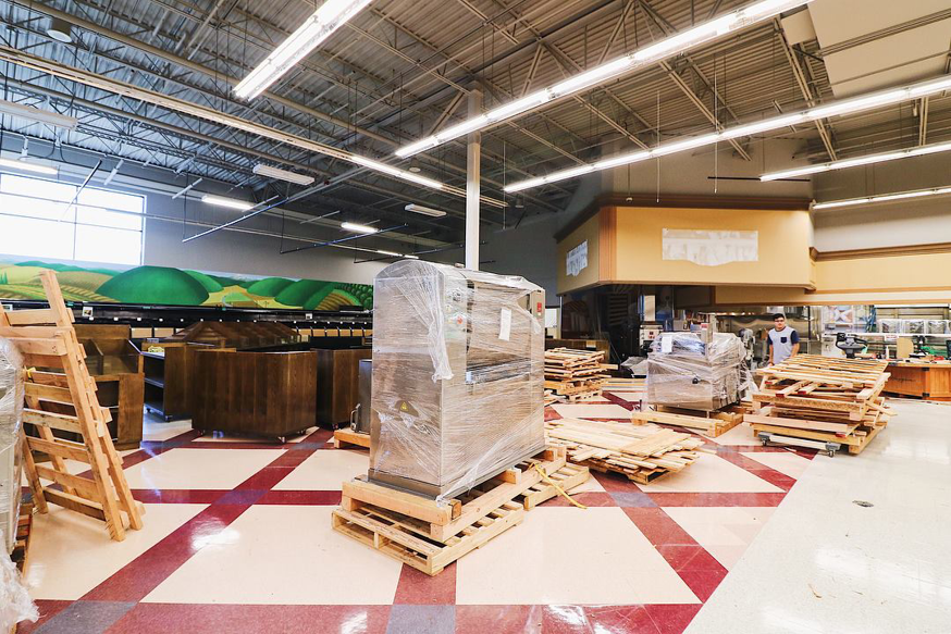 New commercial equipment on pallets awaiting installation in a large space, handled by BFC Construction in Tacoma, WA.