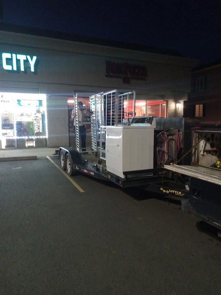Commercial kitchen equipment loaded onto a trailer for removal by Cox Junk & Debris Removal in Buffalo, NY.