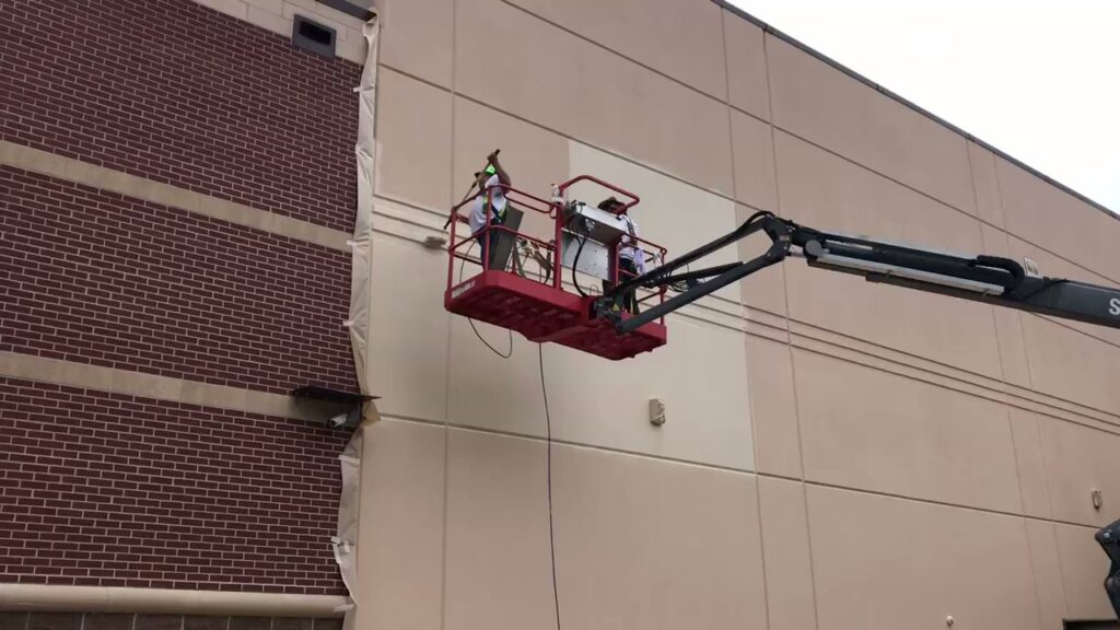 Commercial exterior building painting with a boom lift by Painting Professionals, Inc. in Houston, TX