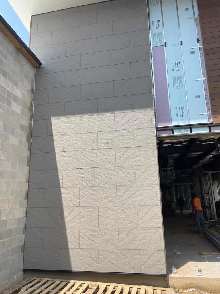 Exterior wall cladding installation with large grey tiles on a commercial building by M&J Florida Enterprise Llc in Orlando, FL.
