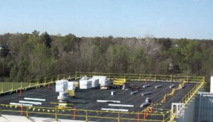 A commercial flat roof under construction with materials and safety railings by RHI Construction Inc in Philadelphia, PA.