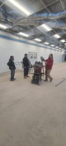 Workers performing commercial floor grinding during a renovation project by Finesse Painting and Remodeling in Fort Worth, TX.