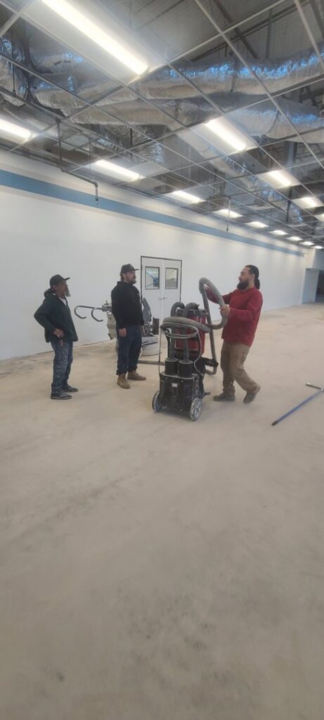 Workers performing commercial floor grinding during a renovation project by Finesse Painting and Remodeling in Fort Worth, TX.